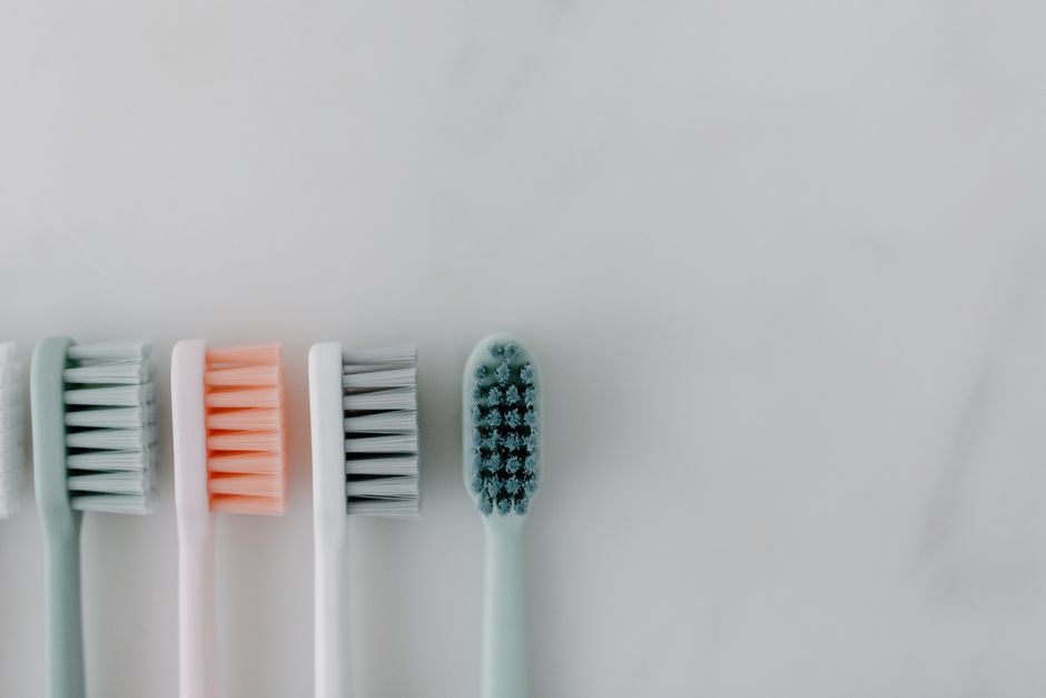 Why Brushing Harder Does Not Clean Better: The Physics and Biology of Tooth Brushing